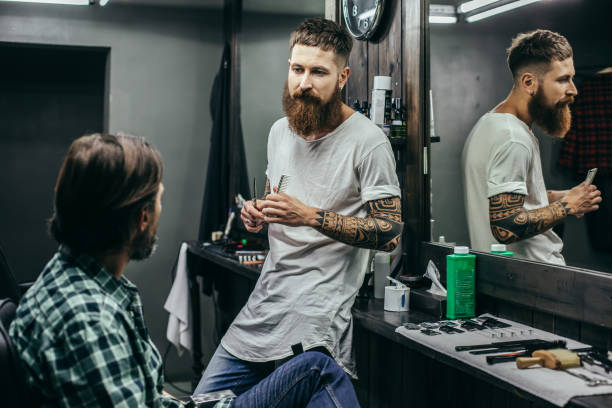 istock Calm barber looking at his client before doing the haircut 1083856296