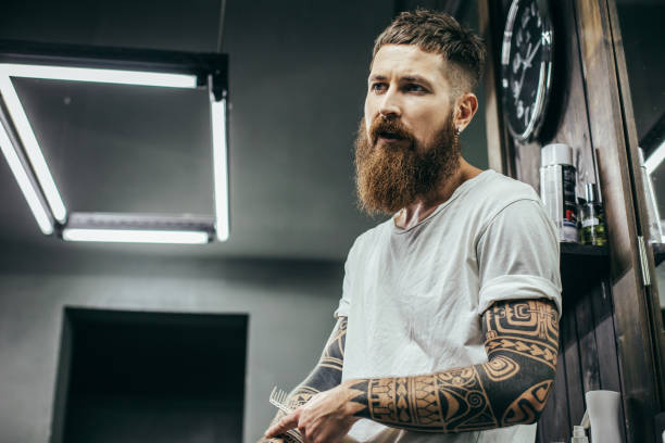 istock Close up of young bearded barber sitting and talking 1083856426