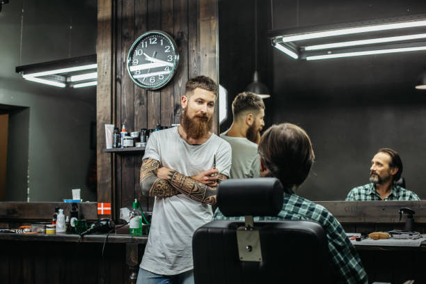 istock Curious barber looking at his client and talking to him 1083856794