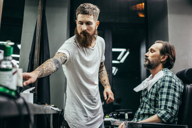 istock Calm man closing his eyes while professional barber working 1083859102