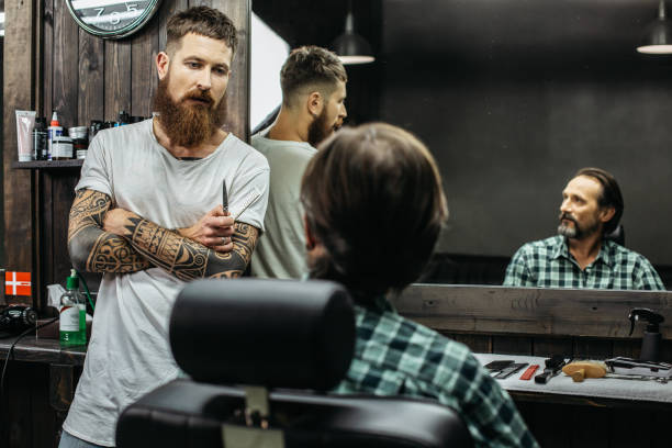 istock Dark haired man looking at the barber while sitting in armchair 1083859476