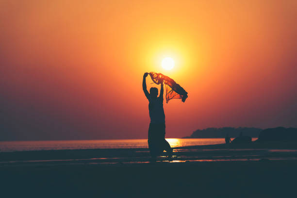 istock Silhouette Man Running With Scarf At Beach Against Sky During Sunset 1083862762