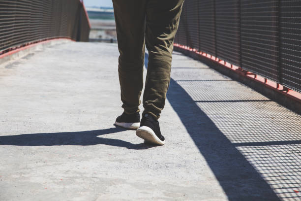 istock Low Section Of Man Walking On Footpath 1083875016