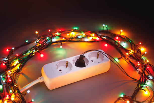 istock Christmas garland lights circle around electric extension cord 1083875250