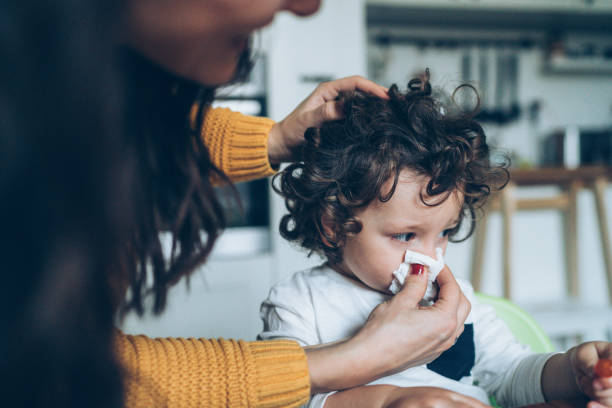 istock Mother helping son to blow his nose 1083879632