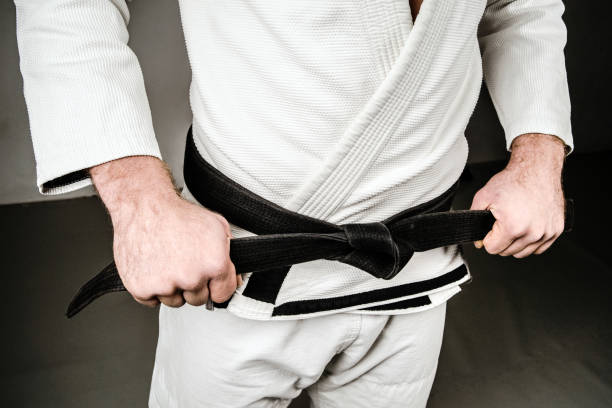 istock Midsection of Man in A Gi holding Black Belt 1083884730