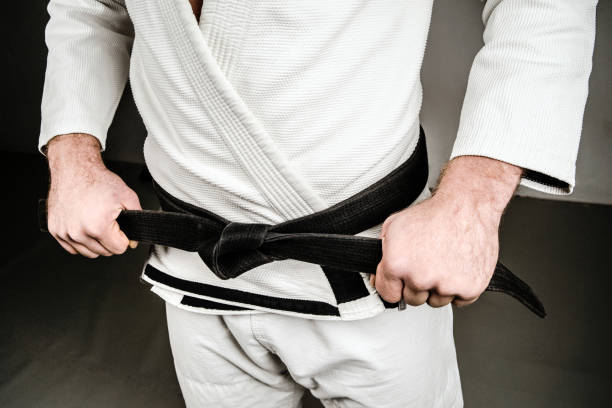 istock Midsection of Man in A Gi holding Black Belt 1083888046