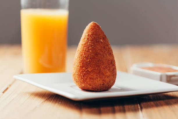 brazilian snack "coxinha" and orange juice on wood table - breadcrumb navigation imagens e fotografias de stock
