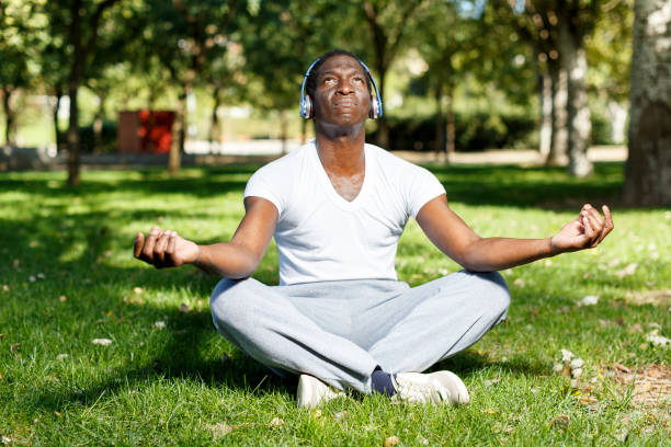 istock Athletic african  american  in headphones  sitting  before training in park 1083901134