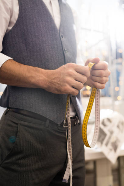 istock Tailor Holding Measuring Tape Close Up 1083903240