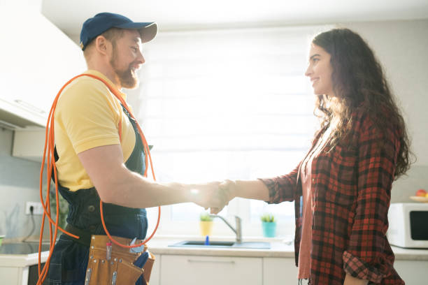 istock Smiling lady thanking repairman for work 1083903854