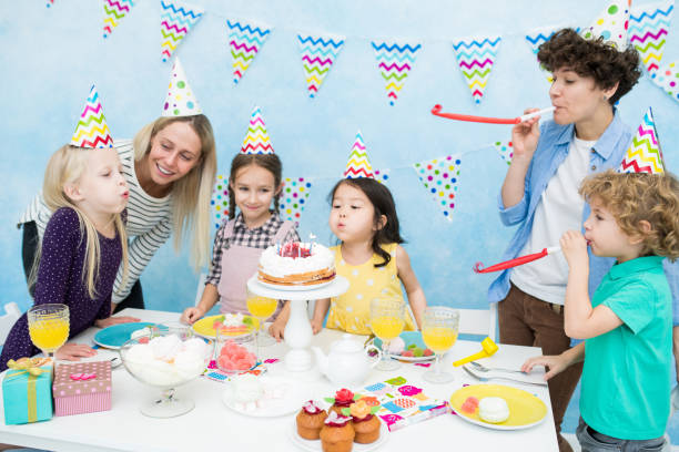 istock Cute girls blowing out candles on cake 1083907218