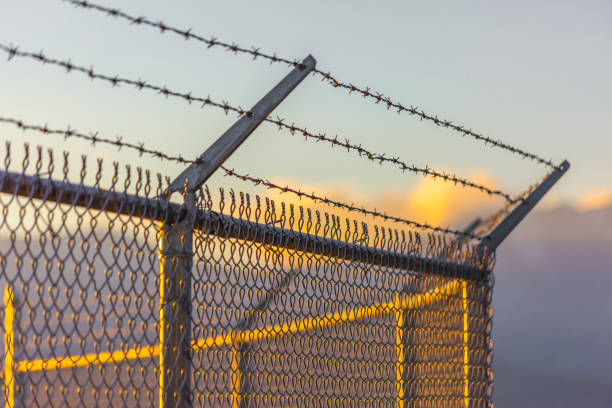 istock Close up barbed wire fence with mountains behind 1083910214