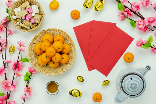 Chinese language mean rich or wealthy and happy.Top view decoration Chinese new year & lunar new year holiday background concept.Flat lay orange with pink flower on white wooden at home office desk.