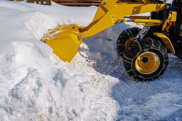 istock Yellow Snow Blade Tractor Vehicle with Snow Chain on Wheels 1083926494