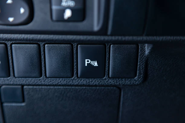 istock Distance sensor button during parking on the center console of the instrument panel close-up inside a modern car in black with white signs and symbols for safe driving. 1083930496