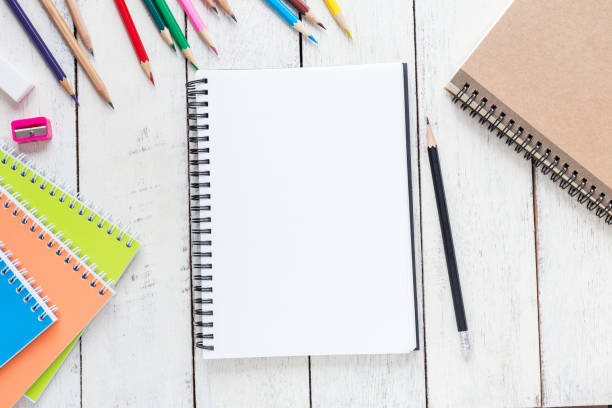 istock Top view, empty notebook and office supplies on the desk. 1083932040