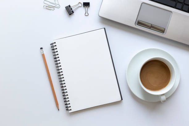 istock Top view, empty notebook with coffee and office supplies on the desk. 1083932066