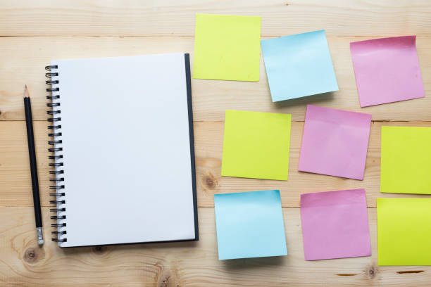 istock Top view Notebook and sticky notes on wooden background. 1083935628