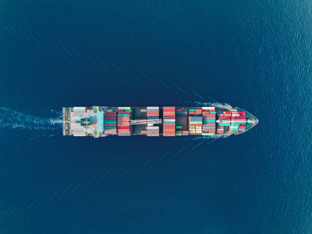 istock Aerial top view container ship on the sea full speed transport container for logistics import export or shipping background. 1083935920