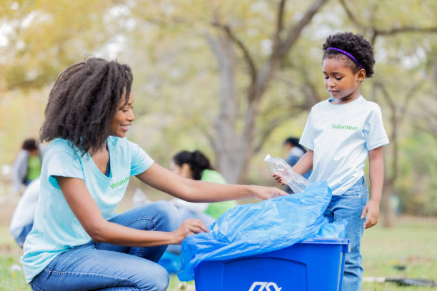 istock Mother helps young daughter recycle during community cleanup 1083936284