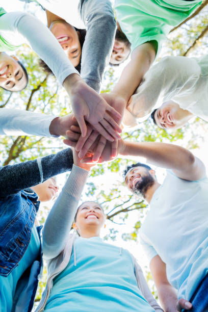 istock View from below as volunteers stack hands outdoors 1083936336