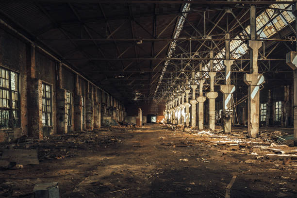 istock Old empty abandoned and ruined factory hall or warehouse inside interior 1083937728