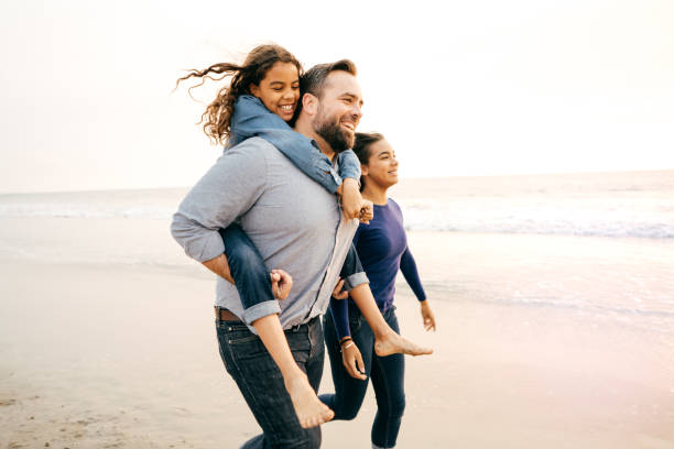 istock Dad running with daughters on the beach 1083939476