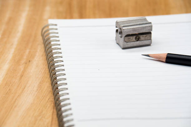 istock close up pencil , pencil sharpener and blank notebook on wooden background. 1083941856