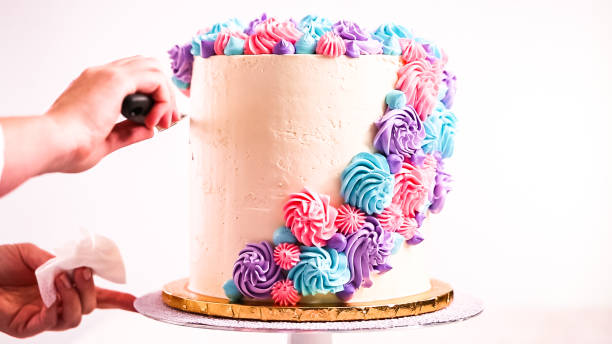istock Piping unicorn eyes with a black buttercream icing on a white cake. 1083947334