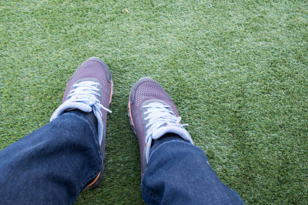 istock Man relaxing, Enjoying.Sneakers on green grass. 1083950466