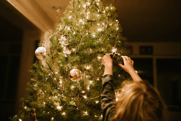 istock Little Girl Decorating Christmas Tree with Ornaments 1083952200