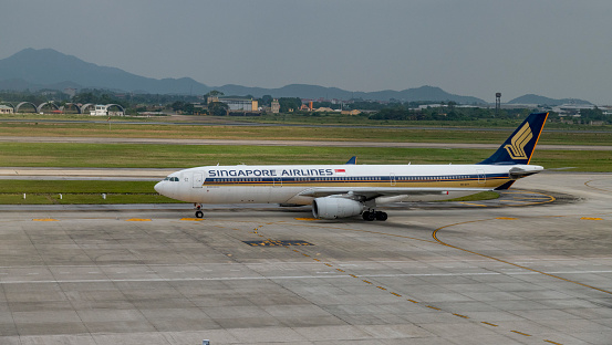 A Singapore Airlines Airbus A330-300 just landed at Hanoi International Airport during a cloudy morning.
