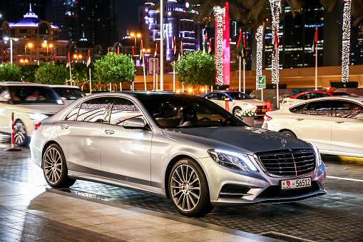 Dubai, UAE - November 18, 2018: Luxury motor car Mercedes-Benz W222 S-class in the night city street.