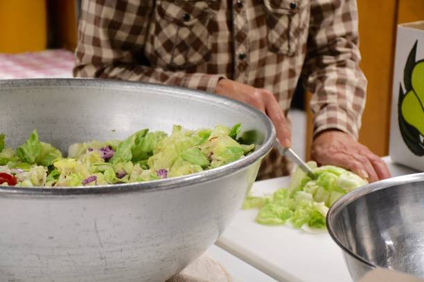 frau hacken salat neben salatschüssel - bigelow stock-fotos und bilder