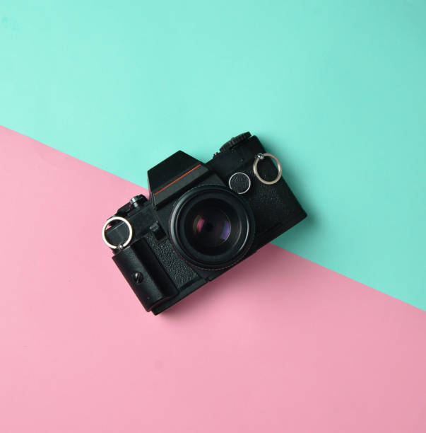istock Retro camera on a colored paper background, flat lay, top view, minimalistic trend. 1083971030
