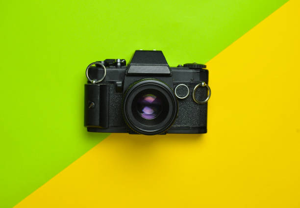 istock Retro camera on a colored paper background, flat lay, top view, minimalistic trend 1083971424