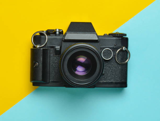 istock Retro camera on a colored paper background, flat lay, top view, minimalistic trend 1083971426