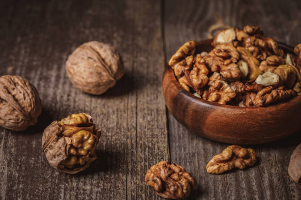 istock close up view of walnuts in bowl on wooden surface 1083973588