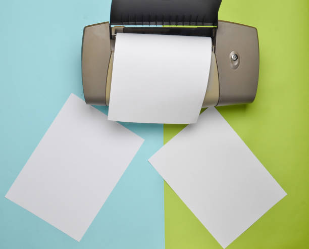 istock printer with blank paper forms on a colored pastel background. Top view, flat lay 1083974758