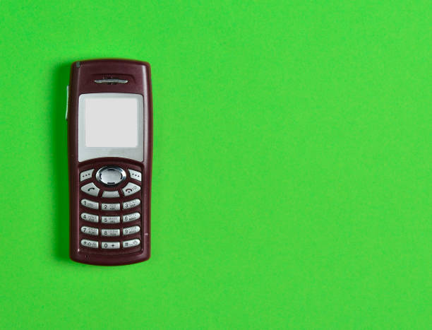 istock Obsolete button phone with a screen for copy space on a green background. Minimalist trend. 1083974862
