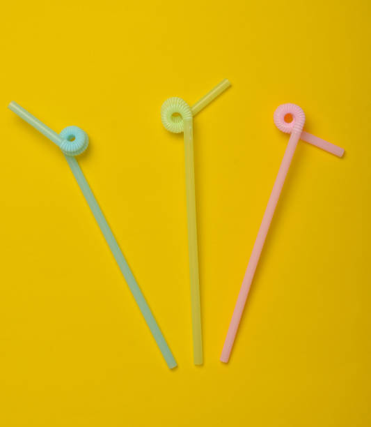istock Colored cocktail tubes on a yellow pastel background. Top view. Copy space. Minimalist trend 1083979054