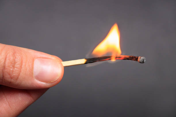 istock Burning match in female hand, isolated on black 1083980734