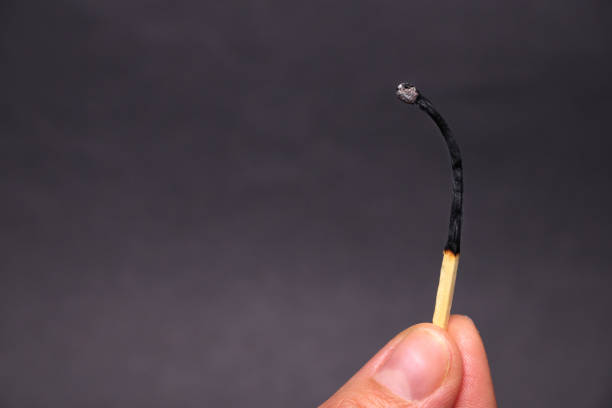 Burning match in female hand, isolated on black