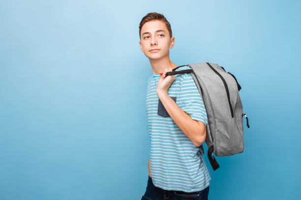Cute teenager with a briefcase, student, on a blue background