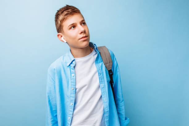 istock guy is listening to music, wireless headphones, on a light blue background 1083981458