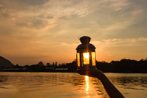 istock lamp on hand in sunbeam over sunset. power and idea concept 1083981530
