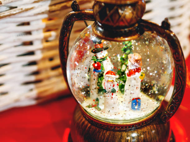 istock Three snowmen inside vintage snow globe with spangles. Christmas retro toy. 1083985600