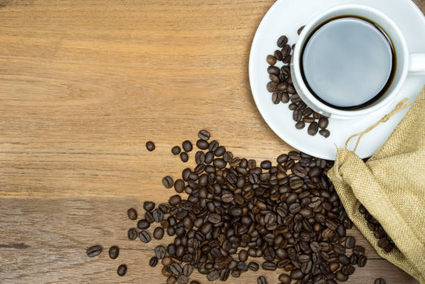 istock Hot Coffee cup with coffee beans with copy space on wooden table. 1083989766