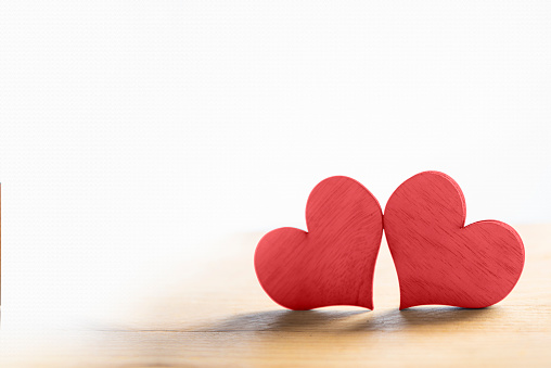 Two red hearts on wooden table with area for copyspace. Love concept and Valentines day